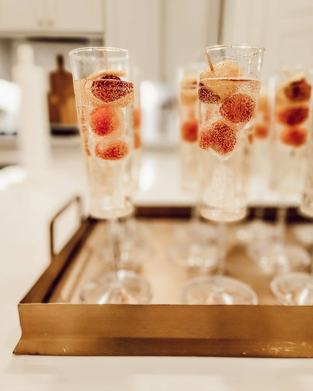 Non alcoholic spritzers with lemon rind and raspberry garnish