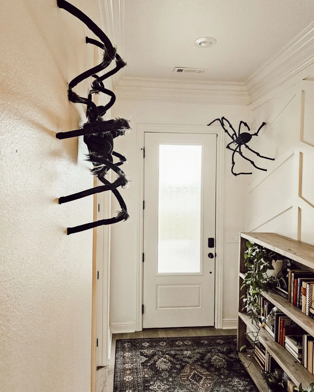 inside the entryway, two out of the three huge spiders climbing on the walls